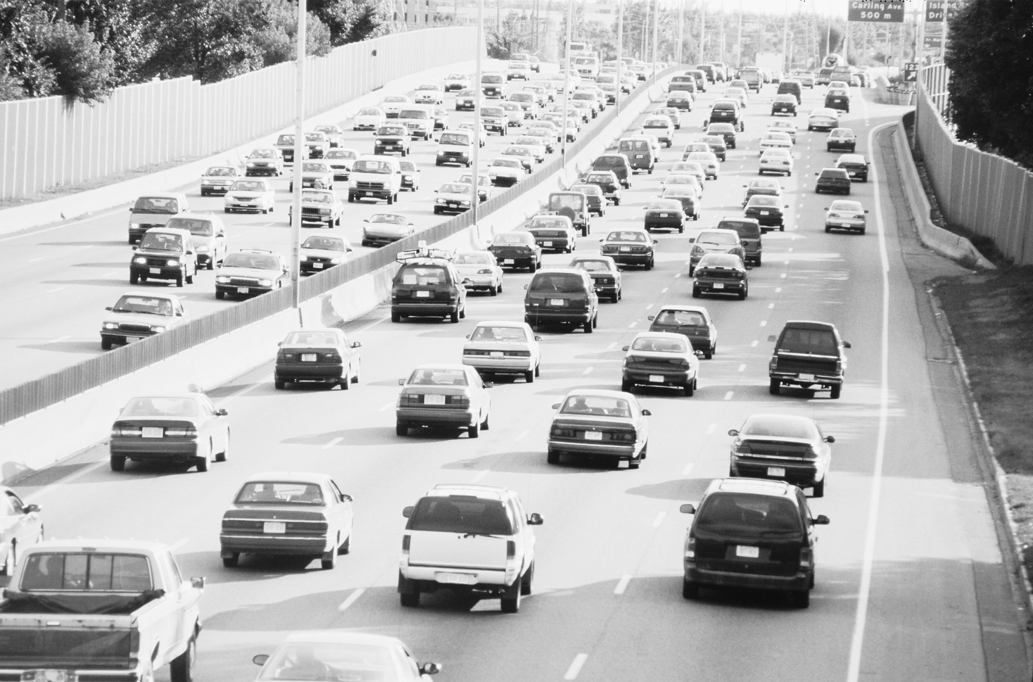 a black and white photo of traffic on a freeway